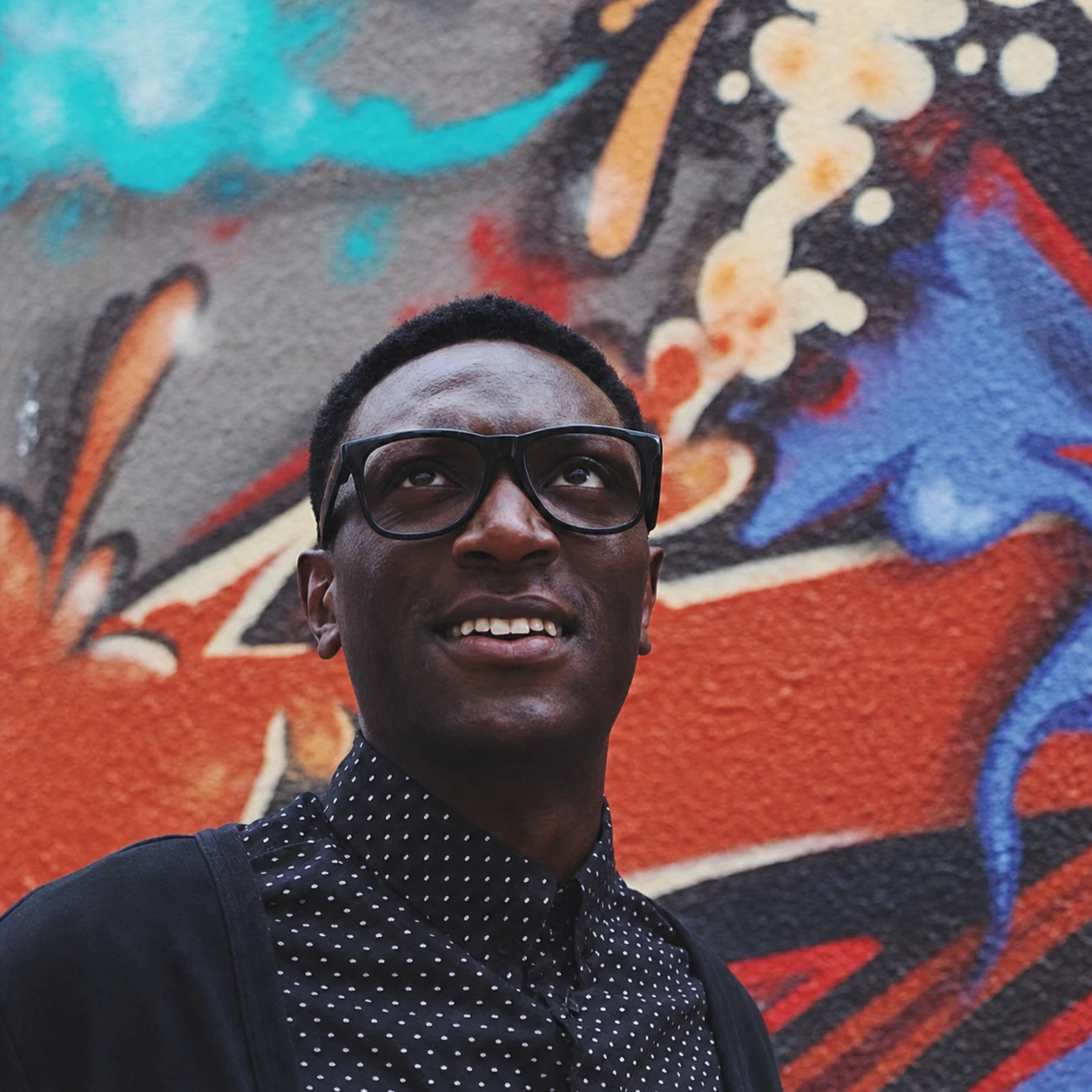 Nigel Joseph standing in front of a colourful mural